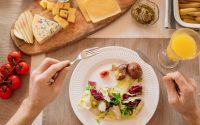 A vibrant lunch setting with salad, cheese, and orange juice, perfect for a healthy meal.